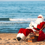 Weihnachtsmann mit Geschenken am Strand