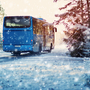 Bus auf Winterstraße durch Nadelwald