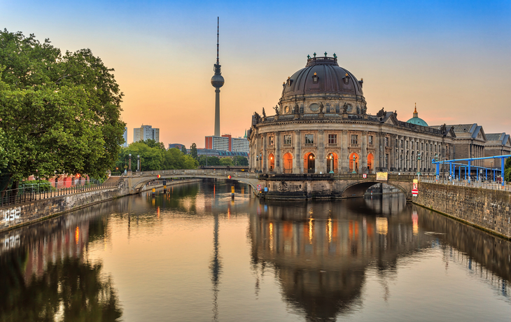 Berlins Skyline bei Sonnenaufgang an der Spree