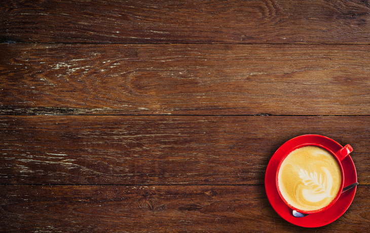 rote Kaffeetasse auf altem Holzhintergrund